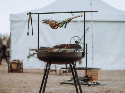 Barebones Cowboy vuurkorf grill systeem met vuur en eten
